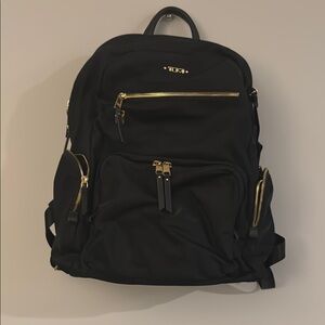 Tumi Black Backpack with Gold Accents and Adjustable Straps